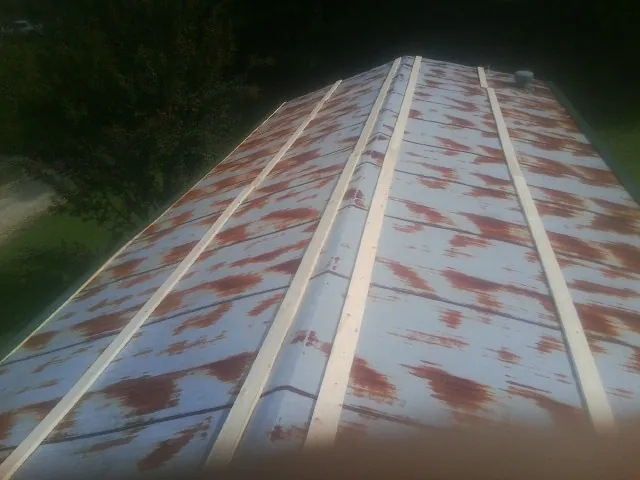 Rusted metal roof panels with new wood purlins before replacement — Storm Damage Roof Repair in Parker City by Roofing Brothers