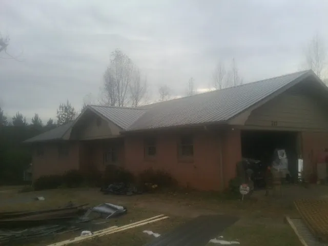 Gray metal roof on a stucco house with an attached garage in Parker City