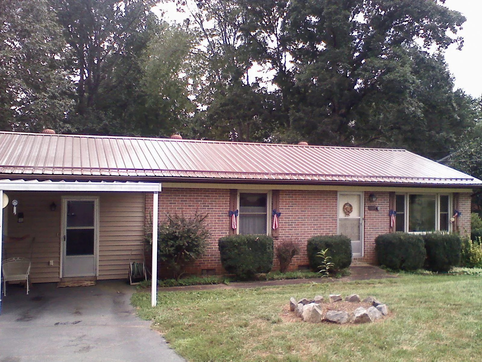 Bronze metal roof and carport on a brick ranch home — Roof Repair work by our crew in Parker City